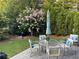 Outdoor patio with furniture set among green trees and manicured landscaping at 6575 Eli Davis Rd, Cumming, GA 30040