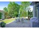 Backyard features a stamped concrete patio with a dining area, outdoor seating, and mature landscaping at 6575 Eli Davis Rd, Cumming, GA 30040