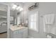 Bright bathroom featuring a single sink vanity, framed art, and window for natural light at 6575 Eli Davis Rd, Cumming, GA 30040
