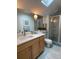 Bathroom featuring a vanity, toilet, shower, and skylight, creating a spa-like retreat at 6575 Eli Davis Rd, Cumming, GA 30040