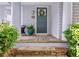 Inviting front entrance with a dark green door, stone steps, and lush greenery at 6575 Eli Davis Rd, Cumming, GA 30040