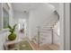 Bright hallway with hardwood floors, stairs, and a view into a sitting room at 6575 Eli Davis Rd, Cumming, GA 30040