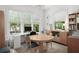 Well-lit home office with a large desk, built-in shelves, and a round table at 6575 Eli Davis Rd, Cumming, GA 30040
