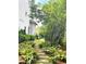 Serene stone pathway in the landscaped backyard with lush ferns and trees at 6575 Eli Davis Rd, Cumming, GA 30040