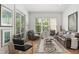 Bright living room with hardwood floors, leather furniture, and large windows at 6575 Eli Davis Rd, Cumming, GA 30040