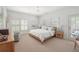 Serene bedroom with neutral tones, a wooden bed frame, and ample natural light at 6575 Eli Davis Rd, Cumming, GA 30040