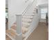 Elegant staircase with white railings and natural wood steps leading to the upper level at 6575 Eli Davis Rd, Cumming, GA 30040