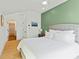 Charming bedroom with light hardwood floors, en suite bathroom, and bright green accent wall at 686 Exchange Se St, Atlanta, GA 30315