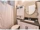 Bathroom with a white cabinet, matching sink vanity, toilet and decorative round mirror at 125 Murphy Creek Ln, Fayetteville, GA 30215
