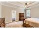 Bedroom featuring carpeted floor, tray ceilings, neutral walls, and large windows for ample natural light at 125 Murphy Creek Ln, Fayetteville, GA 30215