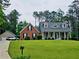 Traditional brick and vinyl home with a well-manicured lawn and mature trees at 125 Murphy Creek Ln, Fayetteville, GA 30215