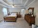 Spacious primary bedroom features a tray ceiling, ceiling fan and stylish furniture at 125 Murphy Creek Ln, Fayetteville, GA 30215