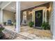 Inviting front porch featuring stone flooring, stacked stone, seating, a wreath and plenty of potted plants at 1495 Old Hunters Lake Dr, Marietta, GA 30062
