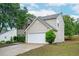 Side view of home with a two-car garage, vinyl siding, manicured lawn, and mature tree at 3230 Deer Valley Nw Dr, Acworth, GA 30101