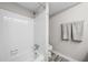The bathroom features a shower and bath, a white tile surround, and wood-look flooring at 6851 Roswell Rd # H12, Atlanta, GA 30328