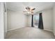 Spacious bedroom with neutral carpet, gray walls, ceiling fan, and window allowing natural light at 6851 Roswell Rd # H12, Atlanta, GA 30328
