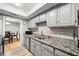 Galley kitchen featuring grey cabinets, granite countertops, and stainless steel appliances with view to dining room at 6851 Roswell Rd # H12, Atlanta, GA 30328