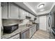 Galley kitchen featuring grey cabinets, granite countertops, and stainless steel appliances at 6851 Roswell Rd # H12, Atlanta, GA 30328
