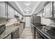 Galley kitchen featuring grey cabinets, granite countertops, and stainless steel appliances at 6851 Roswell Rd # H12, Atlanta, GA 30328