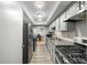 Galley kitchen featuring grey cabinets, granite countertops, stainless appliances and view to dining area at 6851 Roswell Rd # H12, Atlanta, GA 30328