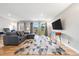 Open-concept living room featuring a gray sectional sofa, hardwood floors, and balcony access at 6851 Roswell Rd # H12, Atlanta, GA 30328