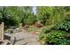 Paver patio with lush, tiered landscaping and mature trees offers a private outdoor living space at 1434 Churchill Way, Marietta, GA 30062