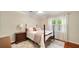 Charming bedroom featuring a cozy bed with decorative pillows, an elegant nightstand, and natural light from the window at 1434 Churchill Way, Marietta, GA 30062