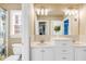Inviting bathroom with white vanity, dual sinks, ample lighting, toilet, and a shower with a floral shower curtain at 1694 Jamie Leigh Ct, Snellville, GA 30078