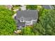 Aerial view of the house showcasing it's architectural design surrounded by lush, mature trees at 2135 Glenfield Trce, Cumming, GA 30041