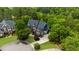 An aerial view of the property showcasing the lush greenery, landscaping, and expansive driveway at 2135 Glenfield Trce, Cumming, GA 30041