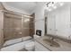 Bathroom features a shower-tub combination with glass enclosure, a granite-top vanity, and neutral finishes at 2135 Glenfield Trce, Cumming, GA 30041