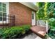 Brick patio with a charming white door surrounded by lush greenery and shrubs at 2135 Glenfield Trce, Cumming, GA 30041
