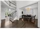 Open-concept dining room featuring hardwood floors, elegant lighting, and staircase view at 2135 Glenfield Trce, Cumming, GA 30041