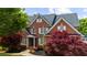 Attractive brick home with white shutters, dormer windows, and a beautifully landscaped yard at 2135 Glenfield Trce, Cumming, GA 30041