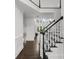 Bright, open foyer with hardwood floors, staircase with black railings, and abundant natural light at 2135 Glenfield Trce, Cumming, GA 30041
