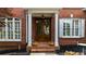 Inviting front entrance with a wooden double door, white columns, and manicured flower beds at 2135 Glenfield Trce, Cumming, GA 30041