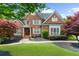 Charming brick home with lush landscaping, mature trees, and a well-manicured lawn at 2135 Glenfield Trce, Cumming, GA 30041