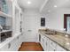 Kitchen features granite countertops, built-in shelves, shaker cabinets, hardwood floors, and stainless-steel appliances at 2135 Glenfield Trce, Cumming, GA 30041