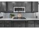 Close-up of modern kitchen with gray cabinets, stainless steel appliances, and marble countertops at 2135 Glenfield Trce, Cumming, GA 30041