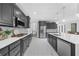 Spacious kitchen with gray cabinets, stainless steel appliances, and a large island with dishwasher at 2135 Glenfield Trce, Cumming, GA 30041