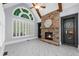 Bright living room with stone fireplace, large arched window, and beamed ceiling at 2135 Glenfield Trce, Cumming, GA 30041