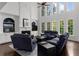 Bright living room with fireplace, soaring windows, and comfortable blue couches at 2135 Glenfield Trce, Cumming, GA 30041