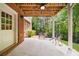 Covered patio with brick columns, seating, and a view of the backyard and landscape at 2135 Glenfield Trce, Cumming, GA 30041