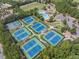 Aerial view of multiple well-maintained tennis courts surrounded by trees at 2135 Glenfield Trce, Cumming, GA 30041