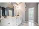 Bathroom featuring double sinks, white cabinets, and a shower with natural light at 3073 Hopeland Dr, Powder Springs, GA 30127
