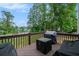 Outdoor deck with a grill, seating, and a view of the surrounding trees at 3073 Hopeland Dr, Powder Springs, GA 30127