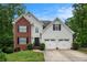 Charming two-story home with a brick accent, attached two car garage, and a well-manicured lawn at 3073 Hopeland Dr, Powder Springs, GA 30127
