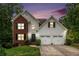 Charming two-story home with brick and siding, black shutters, and a well-manicured lawn at sunset at 3073 Hopeland Dr, Powder Springs, GA 30127