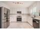Modern kitchen with stainless steel appliances, marble countertops, and ample white cabinetry at 3073 Hopeland Dr, Powder Springs, GA 30127
