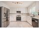 Bright kitchen with white cabinets, stainless steel appliances, and marble countertops and backsplash at 3073 Hopeland Dr, Powder Springs, GA 30127